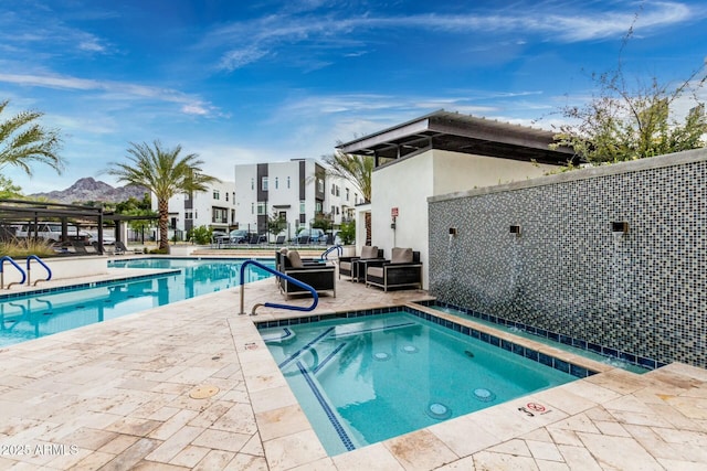 community pool with a patio and a hot tub