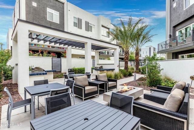 view of patio featuring an outdoor living space with a fire pit, fence, a pergola, and outdoor dining space