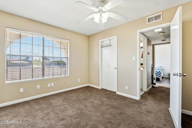 unfurnished bedroom featuring visible vents, a ceiling fan, baseboards, and dark carpet