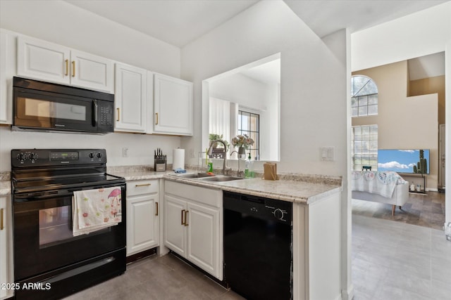 kitchen featuring a sink, black appliances, and white cabinetry