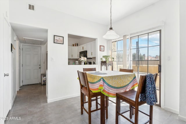 dining room with visible vents, attic access, baseboards, and light tile patterned flooring