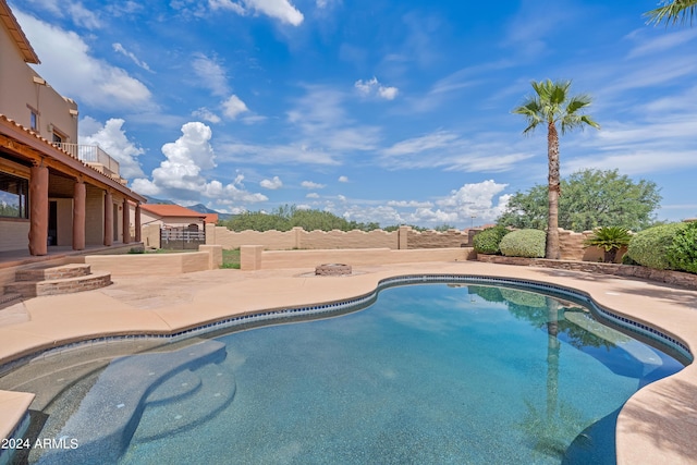 outdoor pool with a patio area and fence