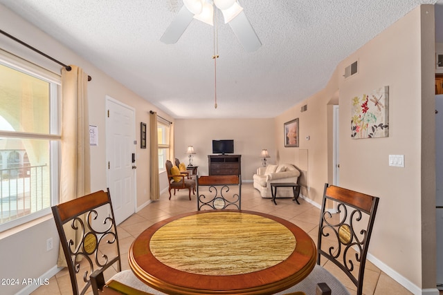 dining room featuring a wealth of natural light, a textured ceiling, and light tile patterned flooring