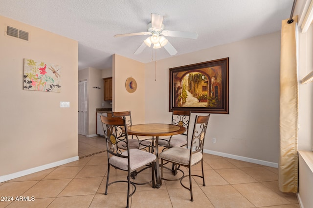 tiled dining space featuring ceiling fan and a textured ceiling