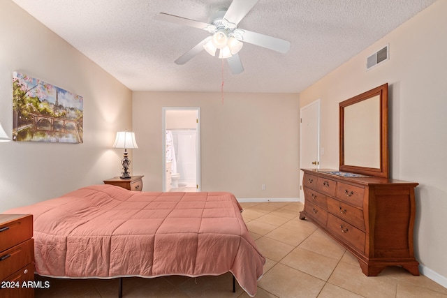 tiled bedroom with a textured ceiling, ceiling fan, and connected bathroom