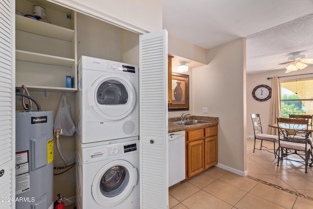 washroom with sink, stacked washer / drying machine, ceiling fan, light tile patterned floors, and water heater