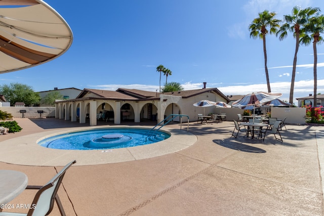 view of swimming pool with a jacuzzi and a patio area