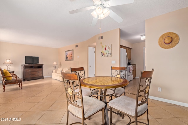 dining space with a textured ceiling, light tile patterned floors, and ceiling fan