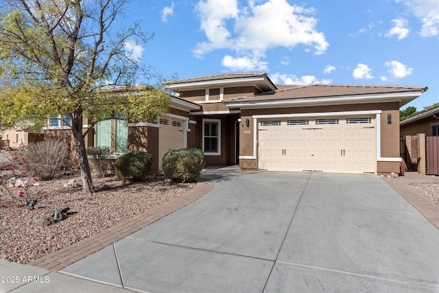 view of front of home with concrete driveway, an attached garage, and stucco siding