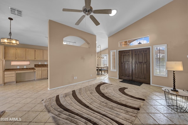 tiled foyer with ceiling fan and high vaulted ceiling