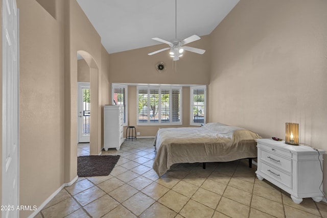 unfurnished bedroom featuring multiple windows, ceiling fan, light tile patterned flooring, and high vaulted ceiling