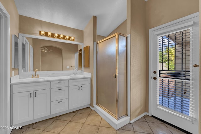 bathroom with tile patterned flooring, ceiling fan, a shower with door, and vanity