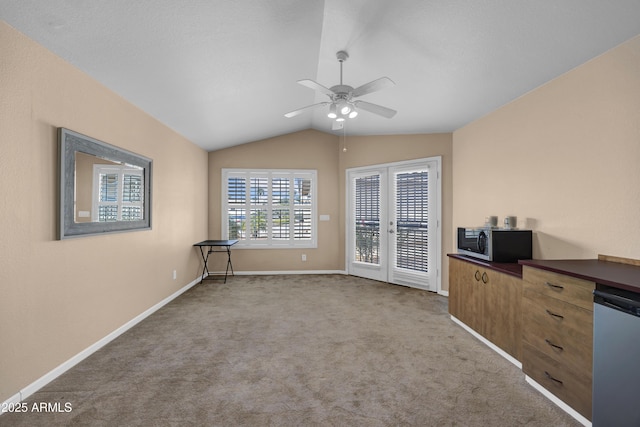 interior space with ceiling fan, french doors, light colored carpet, and vaulted ceiling