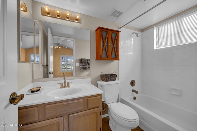 full bathroom with vanity, a wealth of natural light, tiled shower / bath, and toilet