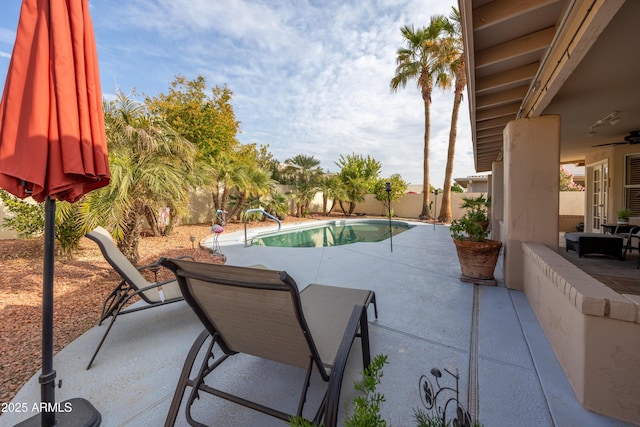 view of swimming pool featuring a patio area and ceiling fan