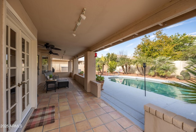 view of patio / terrace with french doors, a fenced in pool, and ceiling fan