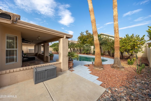 view of patio / terrace featuring a fenced in pool and ceiling fan