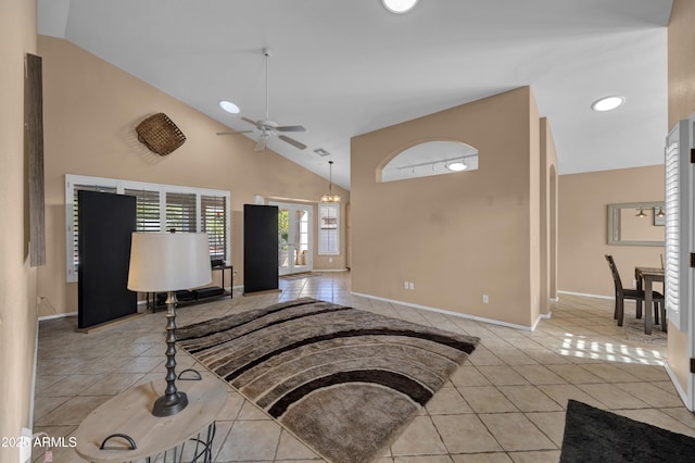 tiled living room featuring ceiling fan and high vaulted ceiling