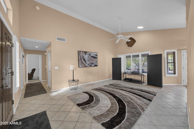 interior space featuring light tile patterned floors, a towering ceiling, and ceiling fan