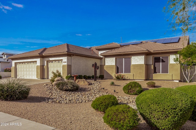 view of front of home featuring solar panels and a garage