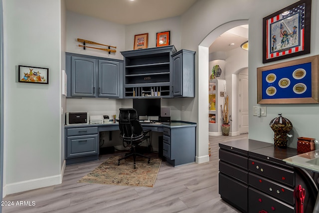 office featuring light hardwood / wood-style flooring and built in desk