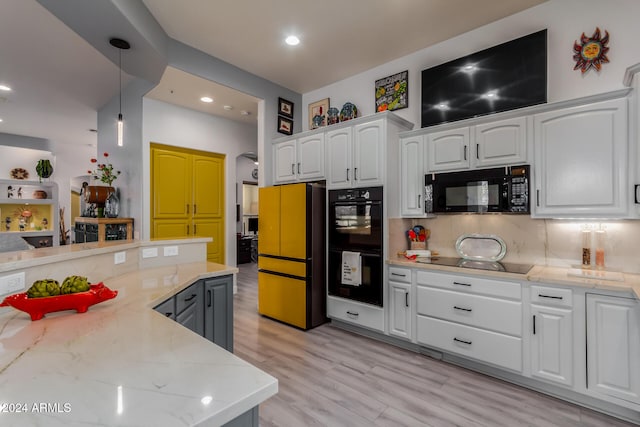 kitchen with light stone countertops, white cabinetry, pendant lighting, and black appliances