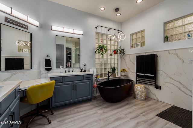 bathroom featuring a bathtub, hardwood / wood-style floors, vanity, and tile walls