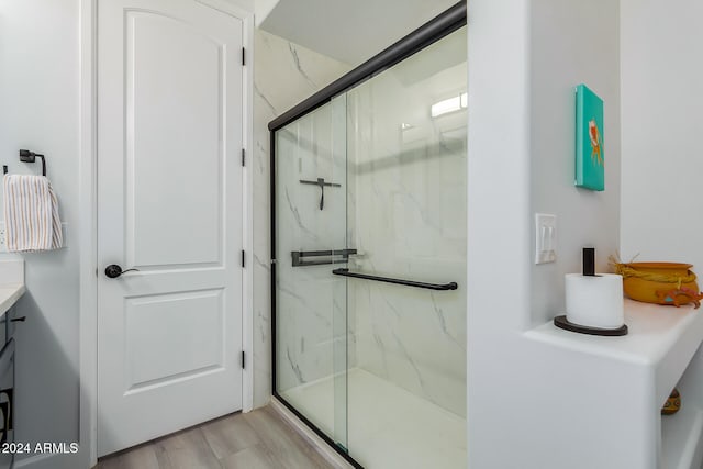 bathroom featuring vanity, an enclosed shower, and wood-type flooring