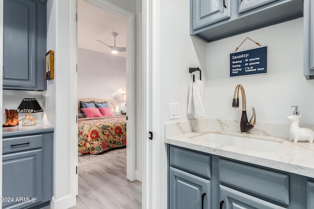 bathroom with hardwood / wood-style floors, vanity, and ceiling fan