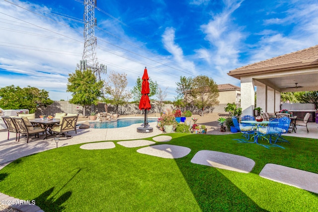 view of yard with ceiling fan, a fenced in pool, and a patio