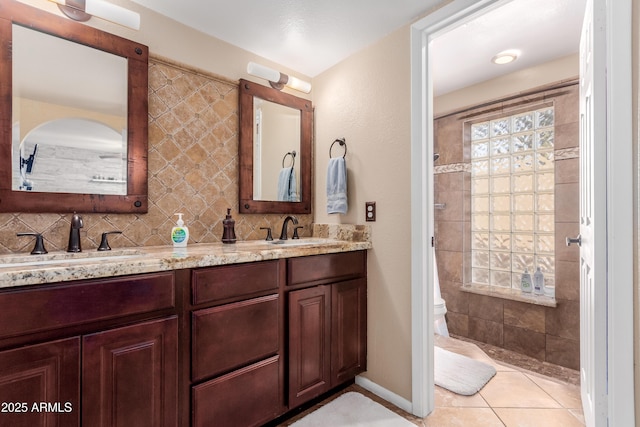 full bathroom with tasteful backsplash, double vanity, toilet, and a sink