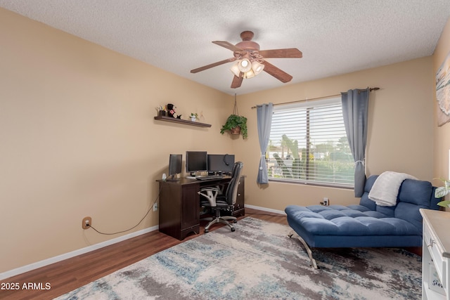 office area featuring wood finished floors, a ceiling fan, baseboards, and a textured ceiling