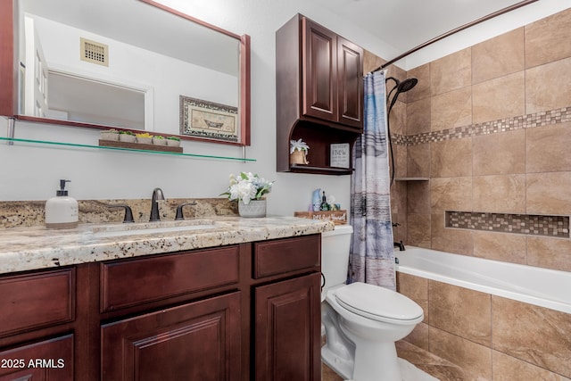 bathroom featuring vanity, toilet, visible vents, and tiled shower / bath combo