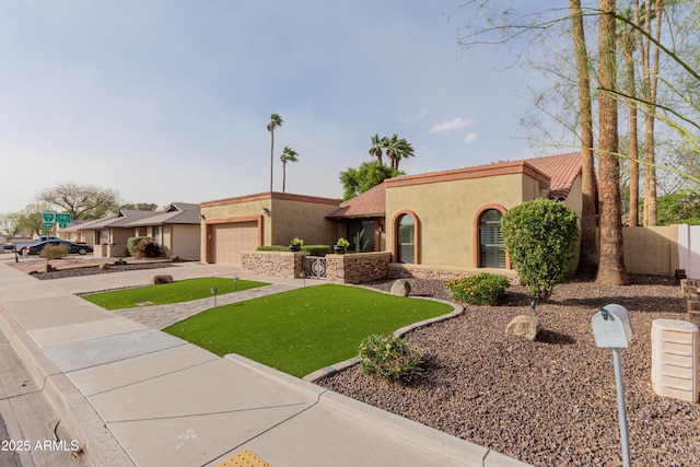 view of front of home with stucco siding, a front lawn, concrete driveway, an attached garage, and a tiled roof