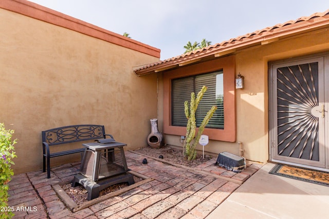 doorway to property featuring stucco siding and a patio