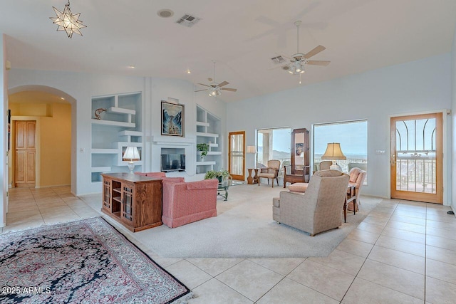 16507 E Trevino Dr, Fountain Hills, AZ 85268 - living area featuring light tile patterned floors, built in shelves, arched walkways, ceiling fan, and visible vents