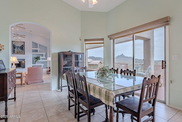 16507 E Trevino Dr, Fountain Hills, AZ 85268 - dining room with built in shelves, a ceiling fan, light tile patterned floors, arched walkways, and a mountain view