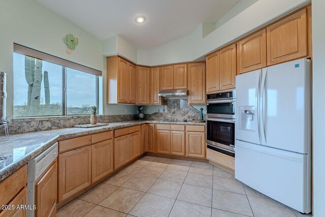 16507 E Trevino Dr, Fountain Hills, AZ 85268 - kitchen featuring white appliances, light brown cabinetry, under cabinet range hood, backsplash, and light tile patterned flooring