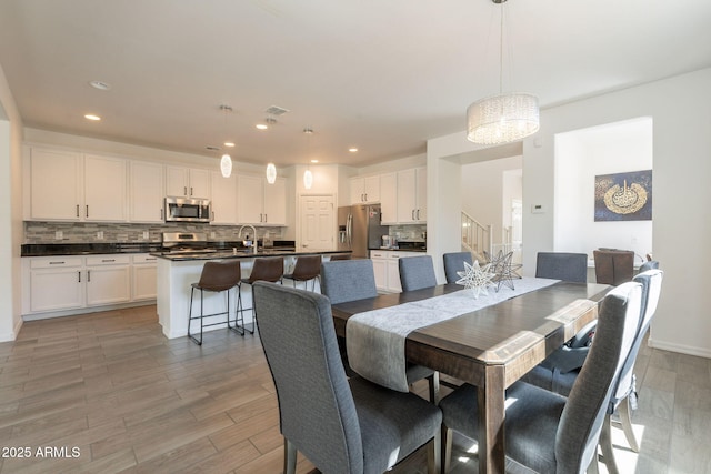 dining space featuring recessed lighting, light wood finished floors, stairs, and visible vents