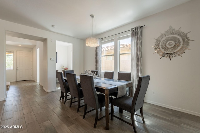 dining space featuring baseboards and dark wood-style floors