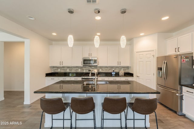 kitchen featuring a sink, appliances with stainless steel finishes, decorative backsplash, and recessed lighting