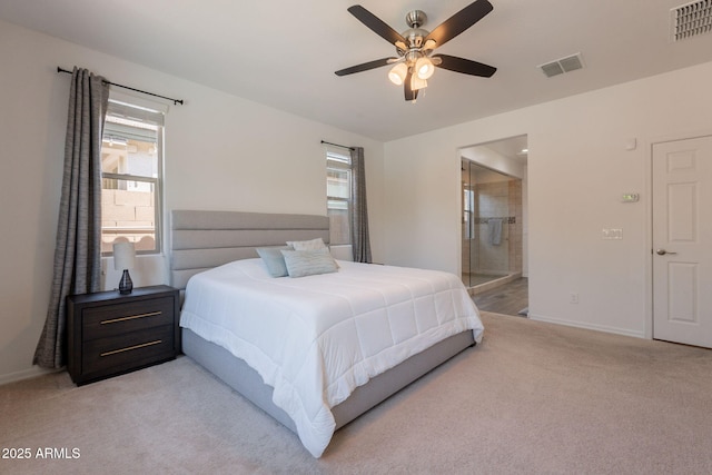 bedroom with baseboards, visible vents, ensuite bath, and light colored carpet
