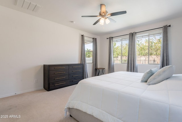 bedroom featuring baseboards, a ceiling fan, light colored carpet, and visible vents