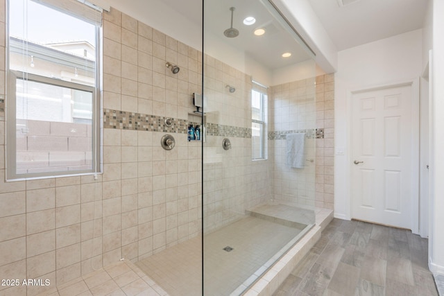 bathroom with a walk in shower, recessed lighting, and wood finished floors