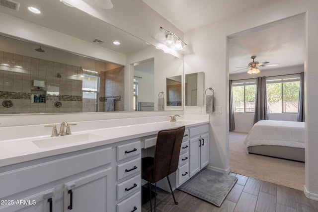 ensuite bathroom with a sink, a walk in shower, double vanity, and visible vents