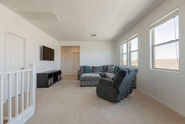 living room featuring visible vents, baseboards, and light colored carpet