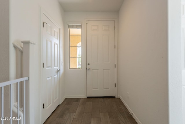 entryway featuring baseboards and dark wood-type flooring
