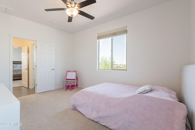 carpeted bedroom with a ceiling fan and visible vents