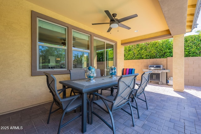 view of patio / terrace with fence, a ceiling fan, outdoor dining area, and a grill