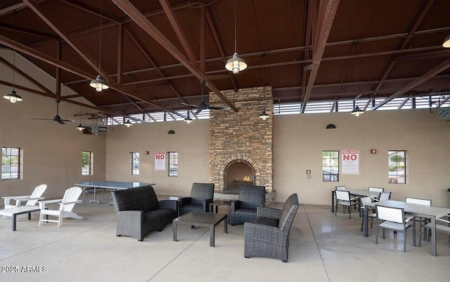view of patio with a ceiling fan, an outdoor living space with a fireplace, and outdoor dining space